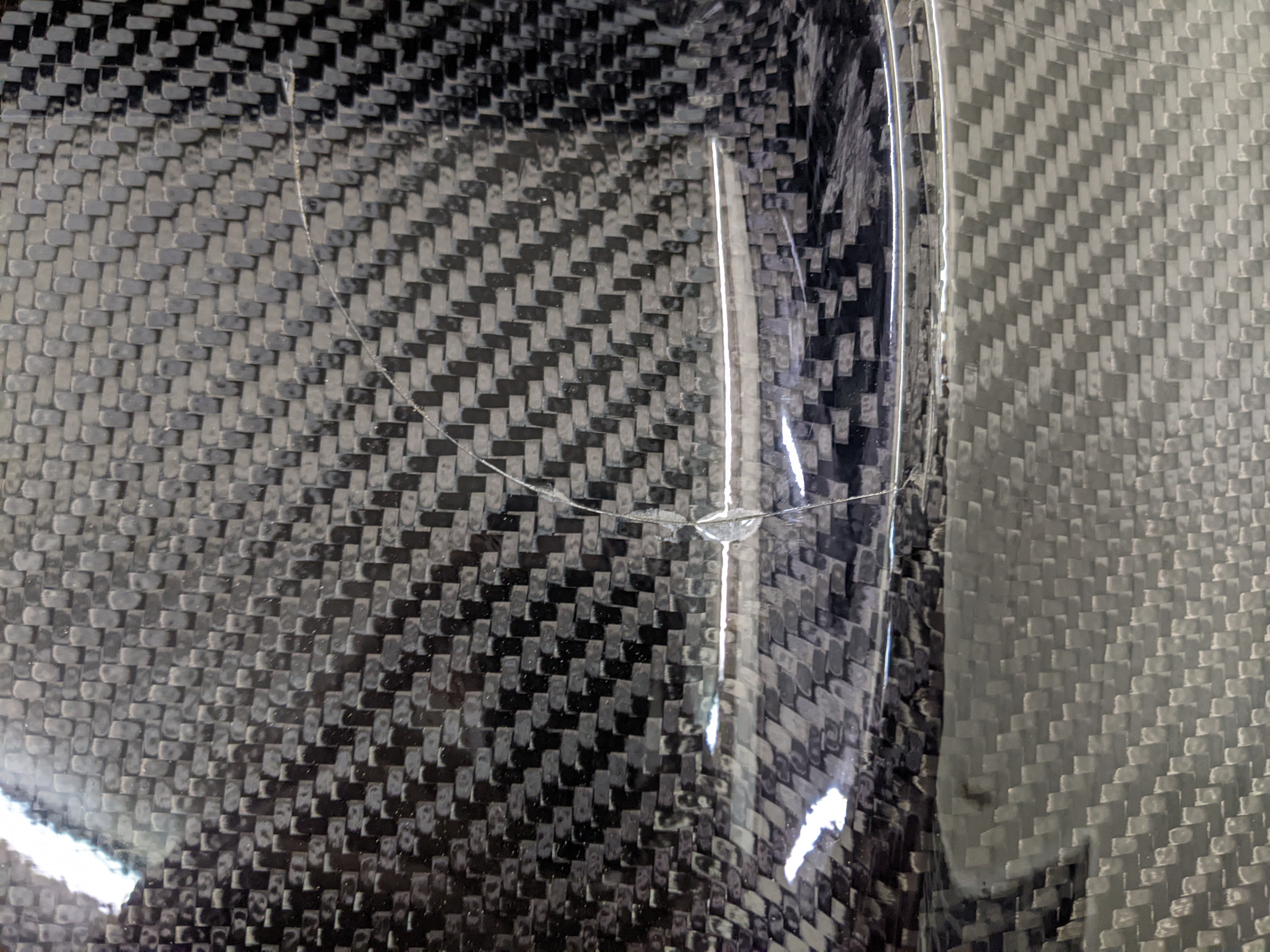 The previous clear bra installer really did a number on this carbon fiber hood. They cut into the hood itself and over time, the carbon fiber hood began to delaminate. What a headache!