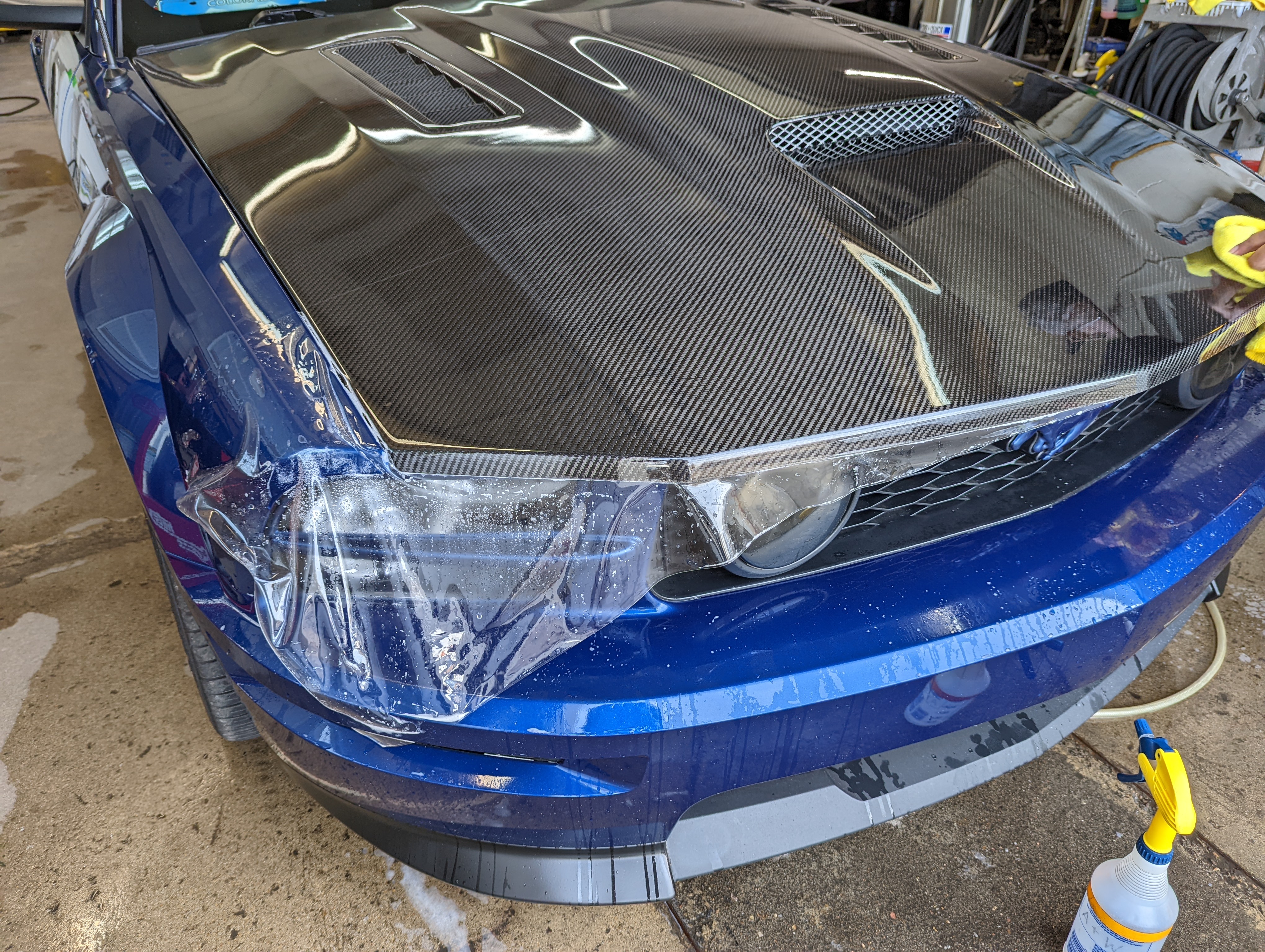 Re-installation of the 18" clear bra on the hood and fenders. We added clear to the "wounded" area to prevent any more de-lamination from happening. No cutting needed to be done on the hood scoop.