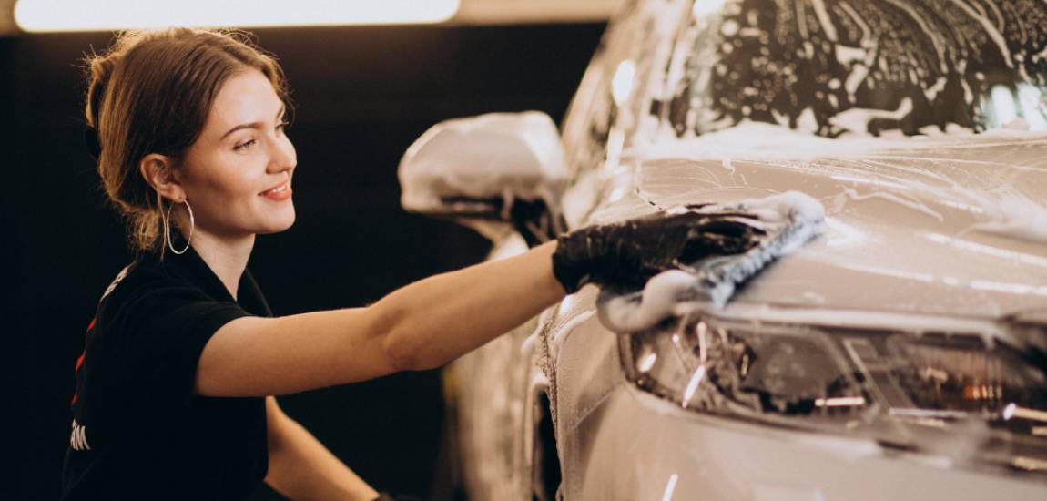 girl washing white car by hand