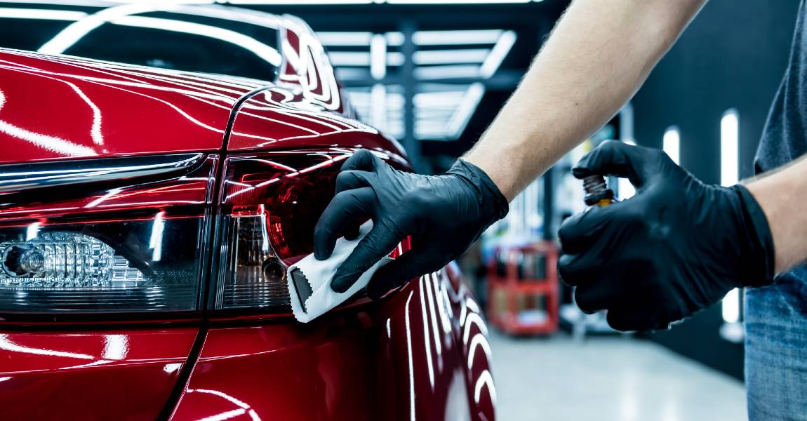 car service tech applying nano ceramic car coating on red car