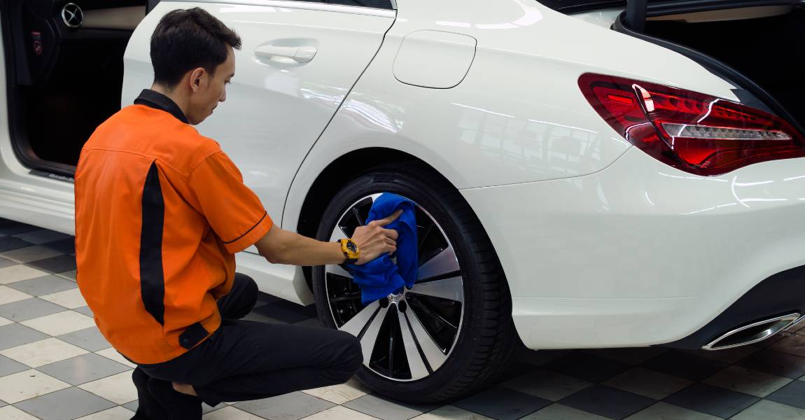 man drying alloy wheels after a ceramic coating application
