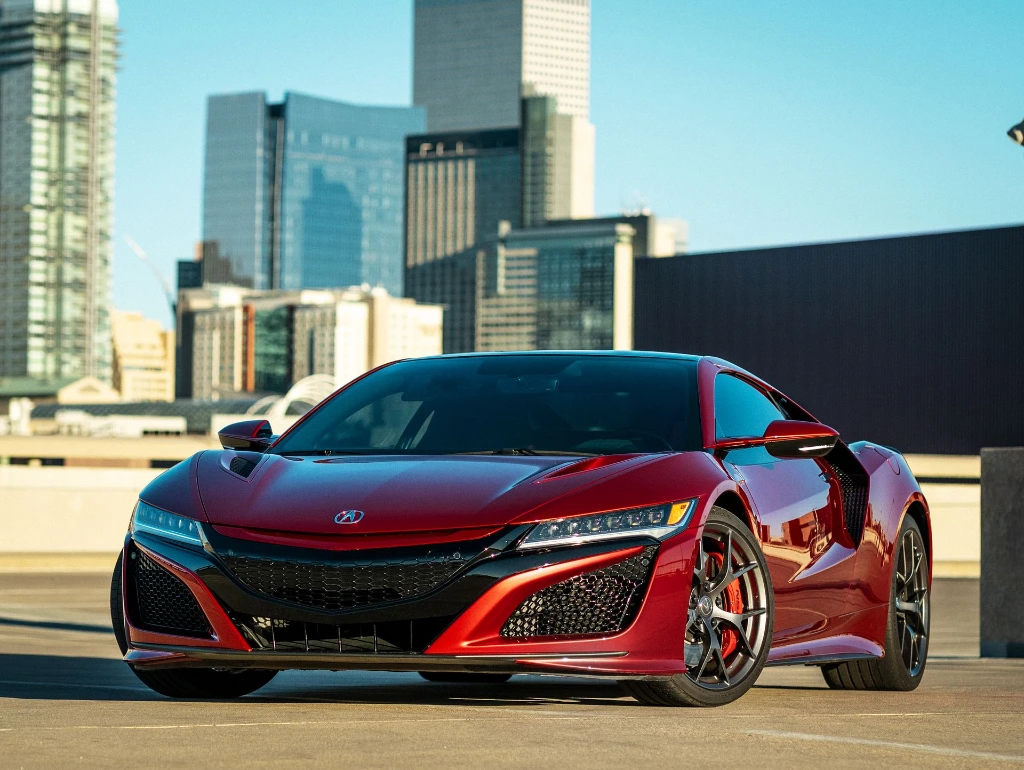 Valencia Pearl 2021 Red Acura NSX sitting in Denver parking garage with Denver skyline behind it