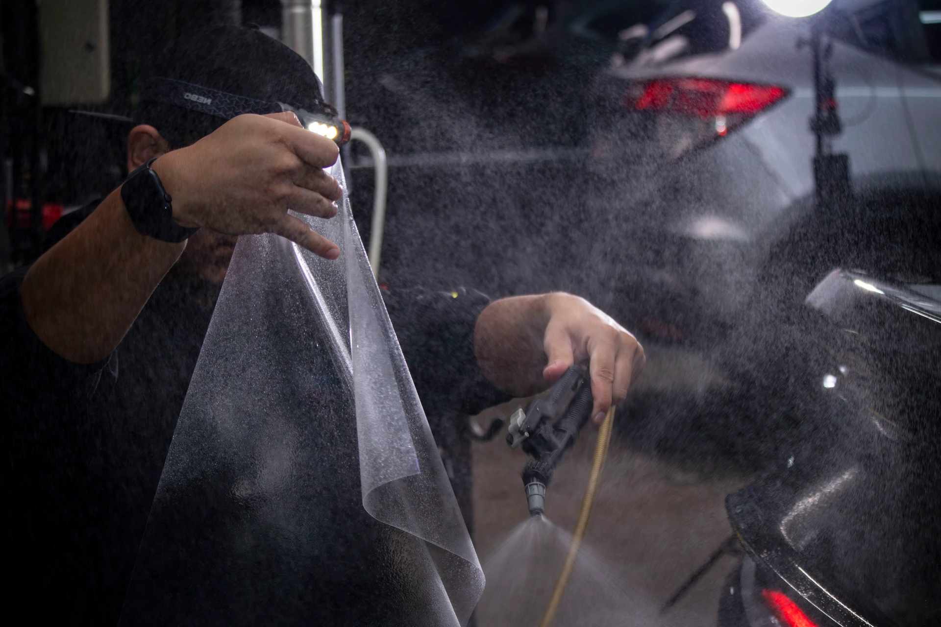 Professional installer applying slip solution to clear bra PPF at Pro-Tech Auto Shield in Wheat Ridge