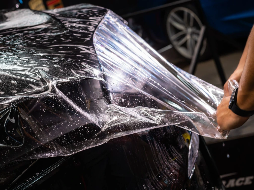 Technician installing and stretching of clear bra PPF on a 2026 Tesla Model X hood at Pro-Tech Auto Shield in Wheat Ridge