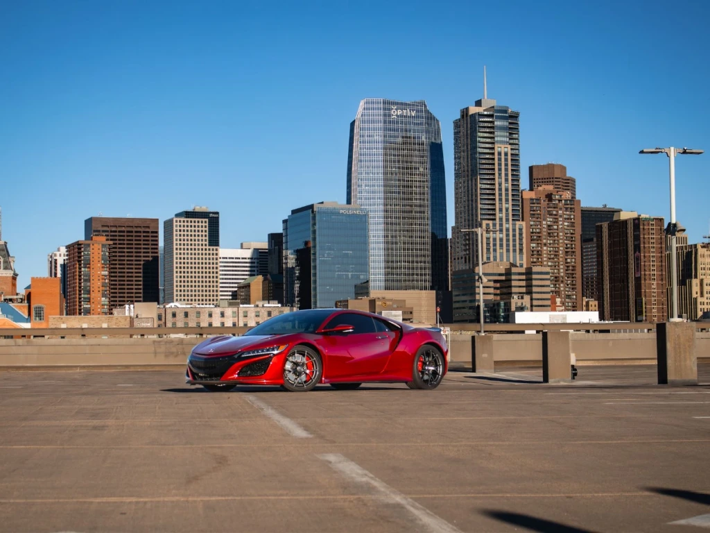 Valencia Pearl Red 2021 Acura NSX with full-body paint protection film parked against the Denver city skyline