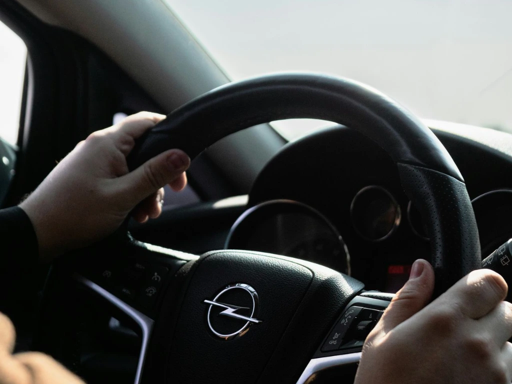 Person holding steering wheel while driving
