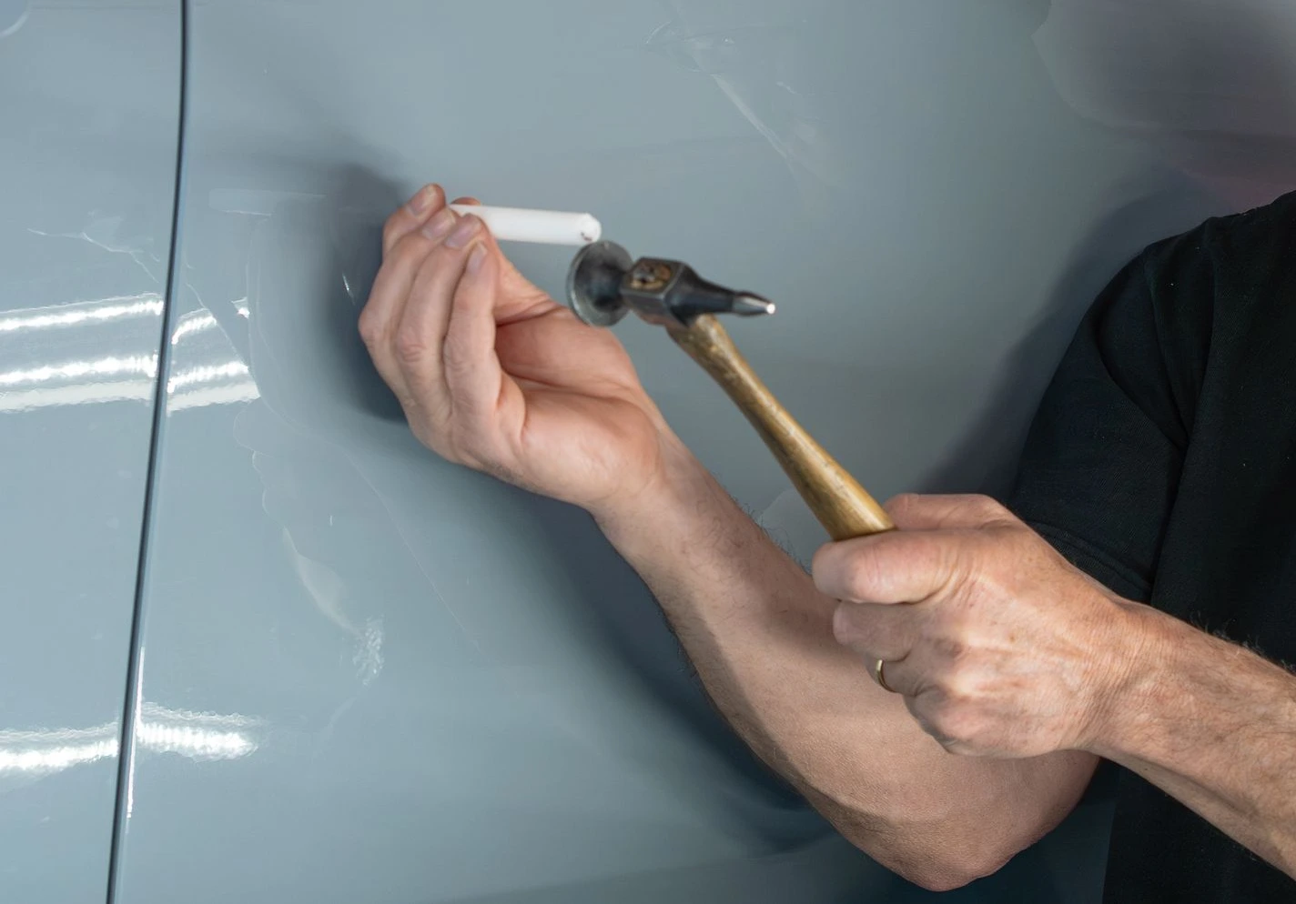 Using a specialized PDR knockdown tool to perfectly level a high spot without damaging the factory paint