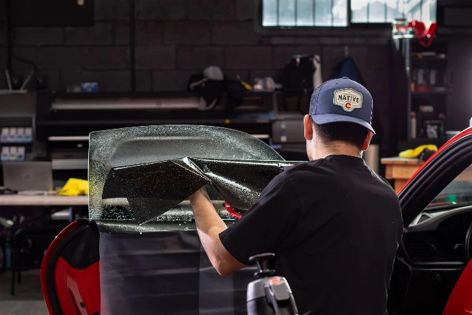 Window tint installer setting window film on driver front door glass