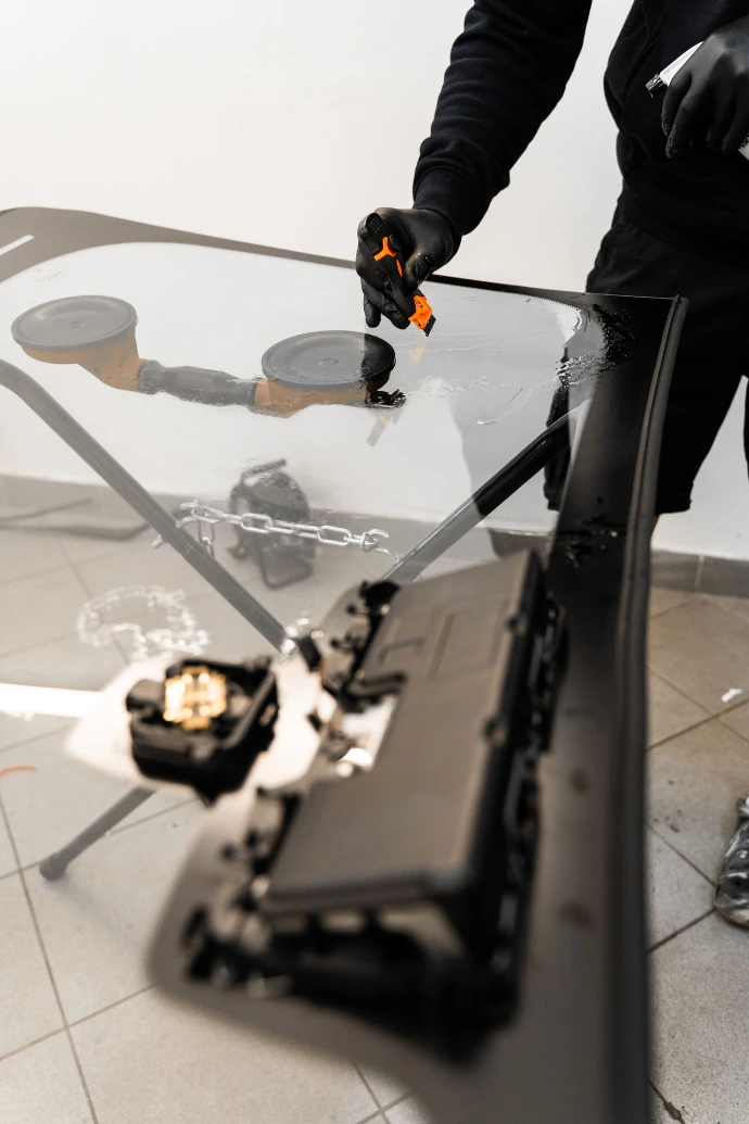 Professional windshield installer preparing a vehicle windshield for installation