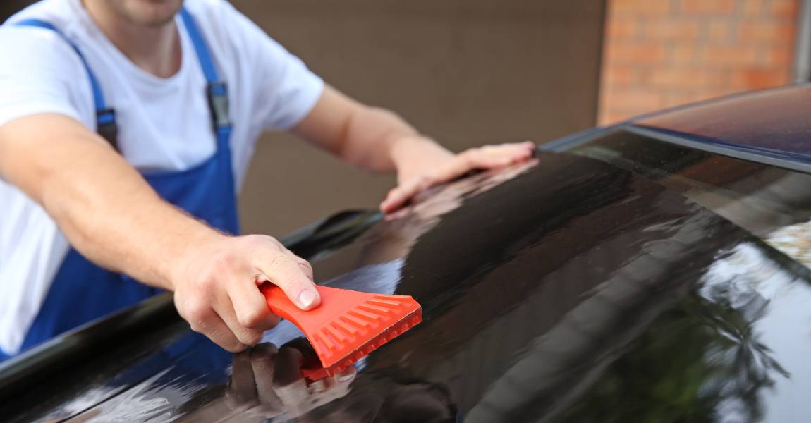 man worker applying window tint to vehicle window