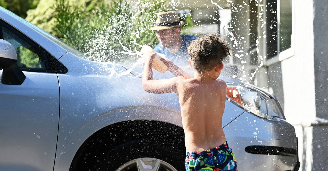 father and son washing car to remove water spots on ceramic coating