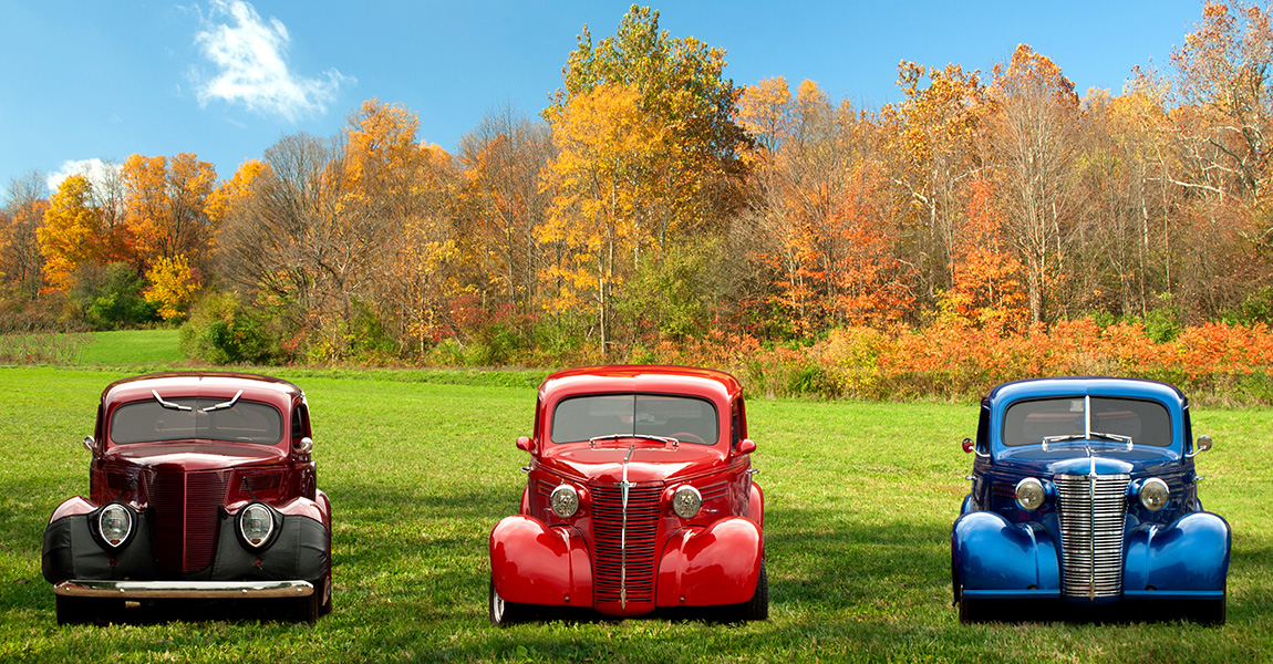 three classic cars in fall setting